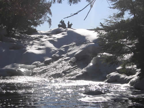 Sun and snow covered rapids.