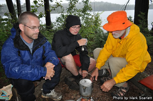 Warming drinks, huddled under a small tarp.