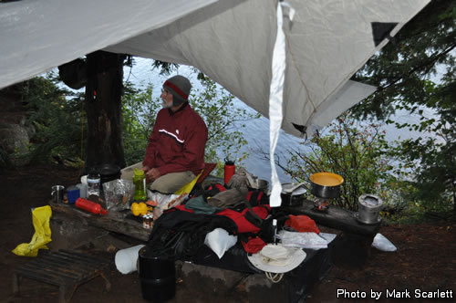 John enjoys a hot drink under the tarp.