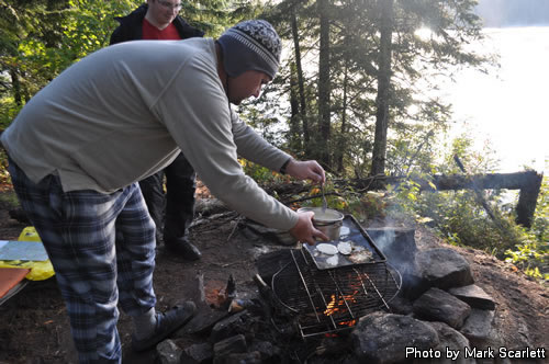 Markus cooking breakfast over a warming fire.