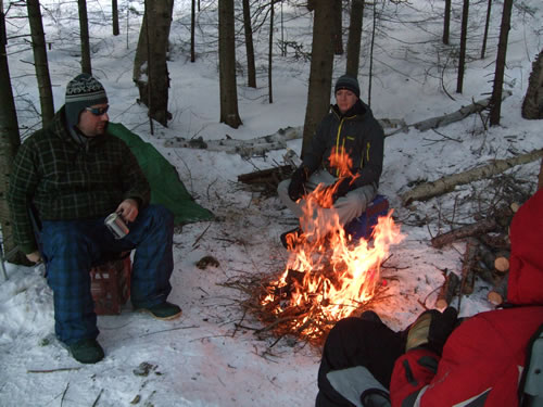 Warming up around a camp fire.