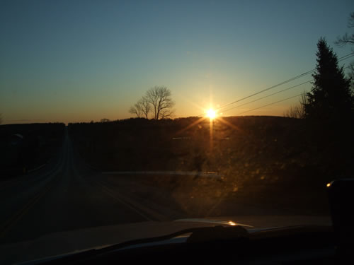 On the road with the sun coming up.